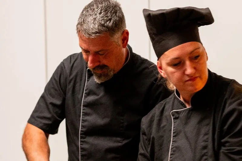 Two chefs preparing seafood in the kitchen of a Calma villa