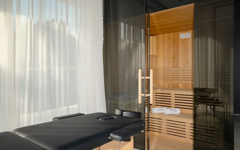 The private sauna at Villa Calma I, beside a massage table and soft white curtains