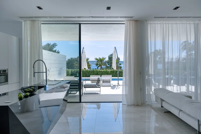 Kitchen island and living room of Villa Calma I opening onto the pool terrace and the sea