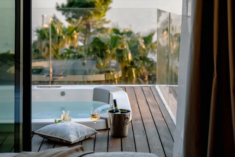 The jacuzzi on the balcony with a glass of wine at sunset