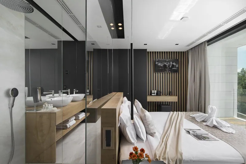 Bedroom with a glass-walled bathroom behind the bed