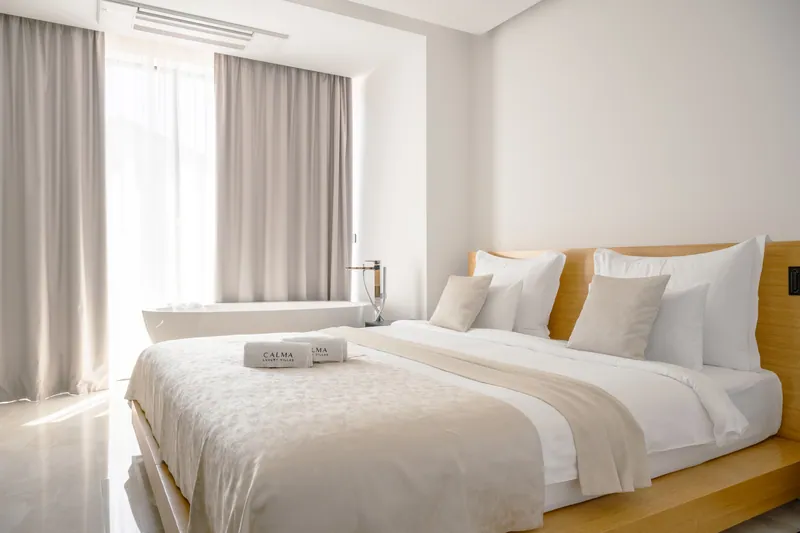 A bright bedroom with a low oak bed