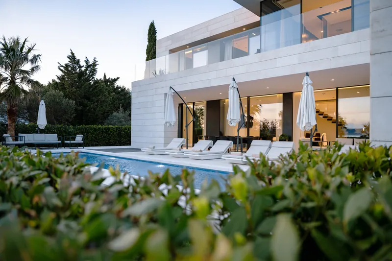 The pool terrace of Villa Calma I seen over the hedge