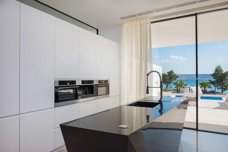 The kitchen and its island, with the pool and the sea beyond