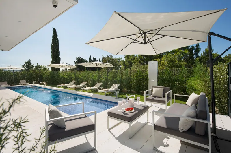 The pool terrace of Villa Calma II, with a lounge under the parasol