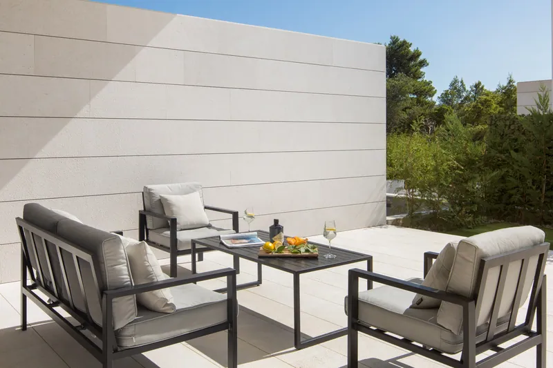Terrace lounge beside the stone wall, with the garden beyond
