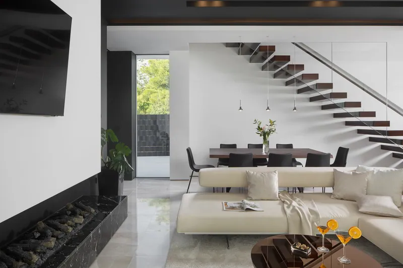 Living room and dining table beneath the floating staircase