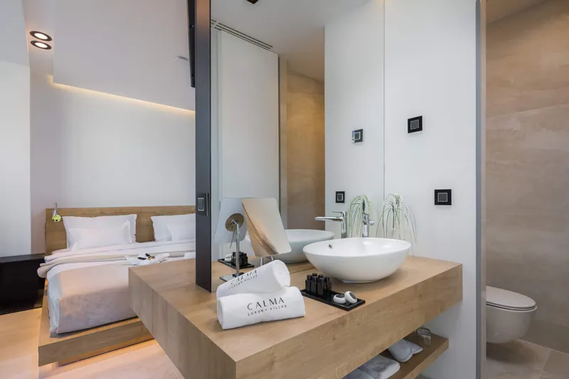 Bedroom with an open bathroom and an oak vanity